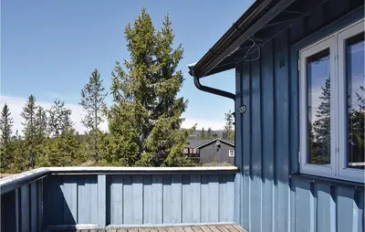 a house with a blue fence and a tree at 3 Bedroom Amazing Home In Sjusjøen in Sjusjøen