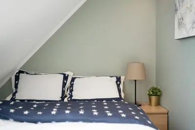 a bedroom with a bed with an american flag pillow at Barfot Apartments in Bergen