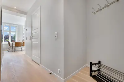 an empty hallway with a door and a bench at Barfot Apartments in Bergen