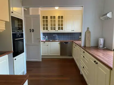 a kitchen with white cabinets and a counter top at Lærdalsøren Motor Guesthouse in Lærdalsøyri