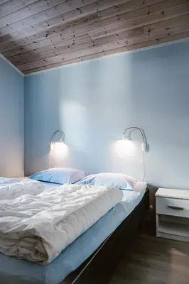 a bedroom with two beds and two lights on the wall at Fossen Accommodation in Geiranger