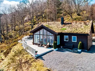 a house with a grass roof with a deck at Serene Waterfront Retreat-By Traum in Valevåg