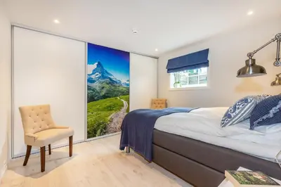 a bedroom with a bed and a chair and a window at Modern Apartment with panorama wiew in Blakset