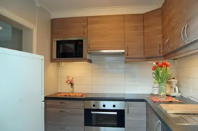 a kitchen with wooden cabinets and a stove top oven at Fjordperlen in Eidfjord
