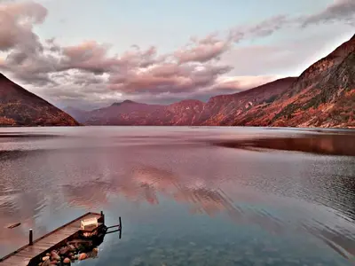 a dock on a lake with mountains in the background at Fjordperlen in Eidfjord