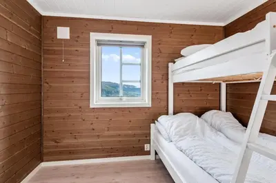 a bedroom with two bunk beds and a window at Pudderhytta in Sogndal