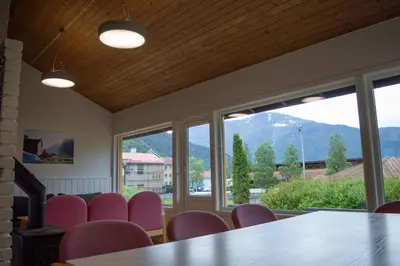 a conference room with a table and chairs and windows at Sogndal Bed & Breakfast in Sogndal