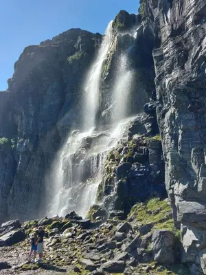 two people standing in front of a waterfall at Nystuen in Tyinkrysset
