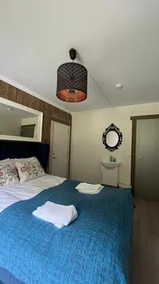 a bedroom with a large bed with a blue blanket at BUDGET Kvamseter Lodge in Eikedalen