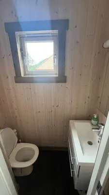a bathroom with a toilet and a sink and a window at BUDGET Kvamseter Lodge in Eikedalen