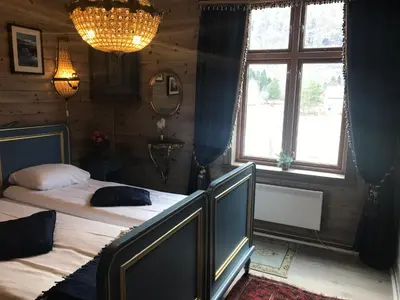 a bedroom with two beds and a window at Eidfjord Gjestgiveri in Eidfjord