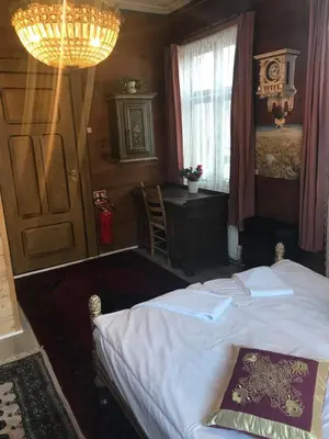 a bedroom with a bed and a table and a window at Eidfjord Gjestgiveri in Eidfjord