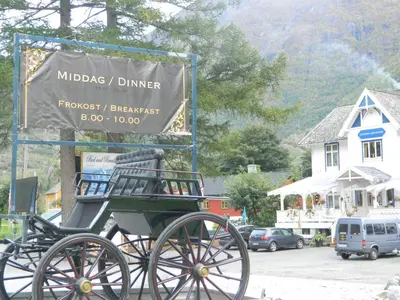 a horse drawn carriage in front of a sign at Eidfjord Gjestgiveri in Eidfjord