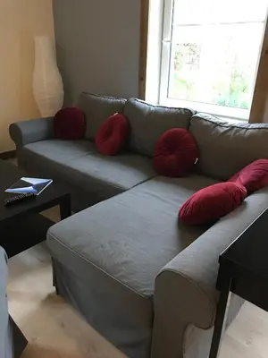 a living room with a gray couch with red pillows at Kvamseter Lodge - Mountain Apartments in Norheimsund