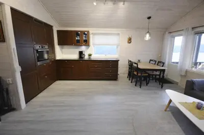 a kitchen and dining room with a table and chairs at Etne Hytter in Etnesjøen