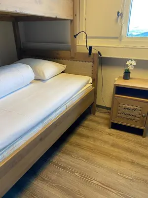 a bedroom with two beds and a table with a lamp at Basecamp Frich`s Hjerkinn in Hjerkinn