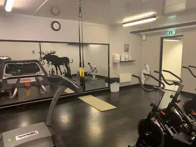 a gym with a treadmill and a bike in a room at Basecamp Frich`s Hjerkinn in Hjerkinn
