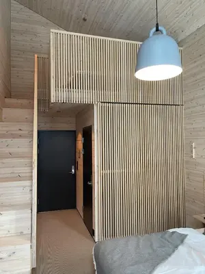 a bedroom with a bed and a blue door at BrimiBue Hotel in Lom
