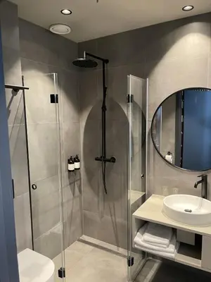 a bathroom with a shower and a sink at BrimiBue Hotel in Lom