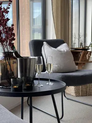 two glasses of wine on a table next to a chair at BrimiBue Hotel in Lom