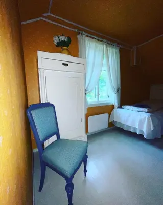 a bedroom with a chair and a bed and a window at Aobrio Holidayhouse, authentic norwegian farmhouse close to Flåm in Lærdalsøyri