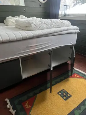 a bed frame with a mattress on it on a rug at Storehorn Apartments Hemsedal in Hemsedal