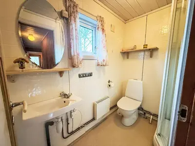 a bathroom with a toilet and a sink and a mirror at Holiday Home Turken by Interhome in Kaupanger