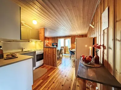 a kitchen with a refrigerator and a table with fruit on it at Holiday Home Turken by Interhome in Kaupanger