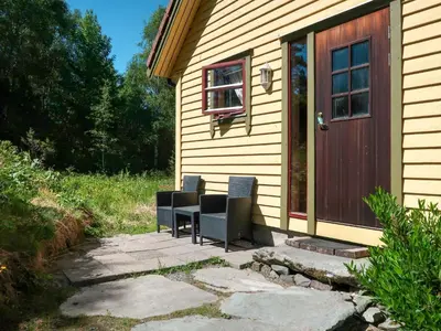 two chairs sitting on a patio next to a house at Holiday Home Rabbane by Interhome in Nyttingsnes