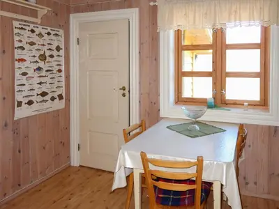 a dining room with a table and a window at Holiday Home Rabbane by Interhome in Nyttingsnes