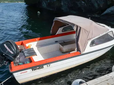 a small boat with a cover on the water at Holiday Home Rabbane by Interhome in Nyttingsnes