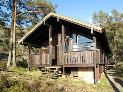a wooden cabin in the middle of a forest at Holiday Home Sandvikfjellet by Interhome in Nyttingsnes