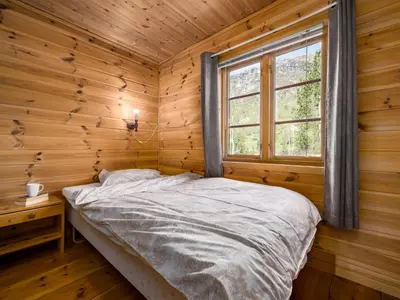 a bed in a wooden room with a window at Holiday Home Lona by Interhome in Viksdalen