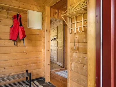 a wooden cabin with a red dress hanging on the wall at Holiday Home Lona by Interhome in Viksdalen