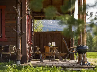 a patio with a table and chairs and a grill at Holiday Home Myravatnet by Interhome in Viksdalen