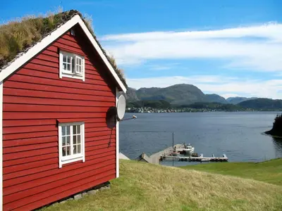 a red house on a hill next to a body of water at Holiday Home Havsblikk by Interhome in England