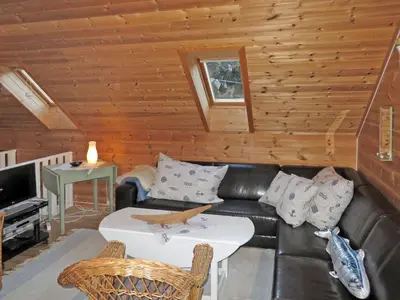 a living room with a leather couch and a table at Holiday Home Tufto by Interhome in Lunde