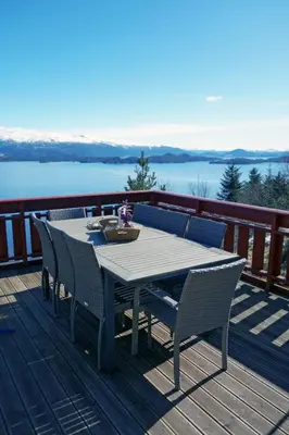 a table and chairs on a deck with a view of the water at Holiday Home Elistova by Interhome in Onarheim