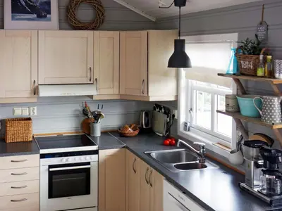 a kitchen with wooden cabinets and a sink at Holiday Home Elistova by Interhome in Onarheim