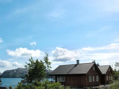 a wooden house with a view of the water at Holiday Home Blåbærhytta by Interhome in Onarheim