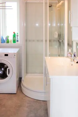 a bathroom with a shower and a washing machine at Holiday Home Tyttebærhytta by Interhome in Onarheim