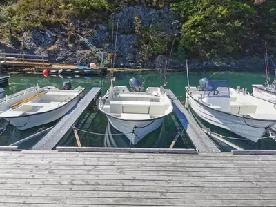 three boats are docked at a dock in the water at Holiday Home Tyttebærhytta by Interhome in Onarheim