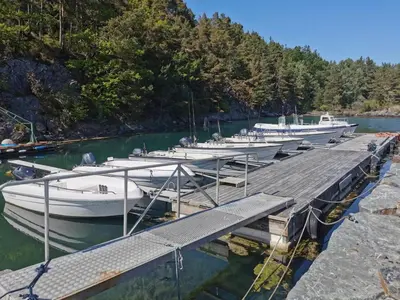 a group of boats docked at a dock in the water at Holiday Home Tyttebærhytta by Interhome in Onarheim