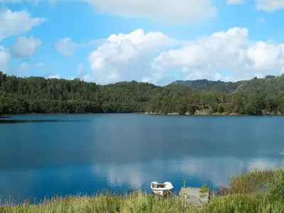 a lake with a boat in the middle of it at Apartment Rorbuen by Interhome in Uggdal