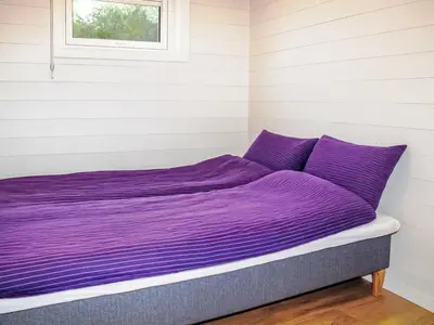a purple bed in a room with a window at Apartment Rorbuen by Interhome in Uggdal