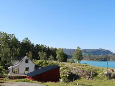 a house on a hill next to a body of water at Holiday Home Bjørkeneset by Interhome in Uggdal