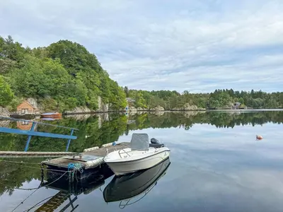 a boat is docked at a dock on a lake at Chalet Gulehuset by Interhome in Gjelland