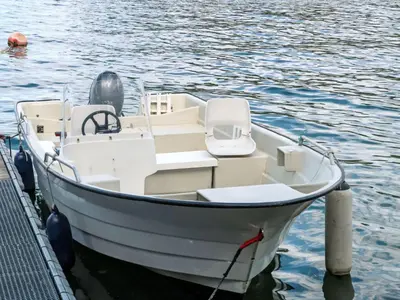 a white boat tied to a dock in the water at Holiday Home Gule huset by Interhome in Bruntveit