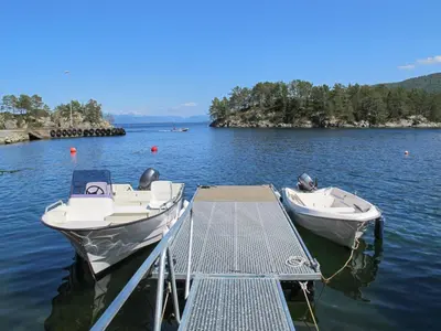 two boats are docked at a dock on a lake at Holiday Home Gamlahuset by Interhome in Bruntveit