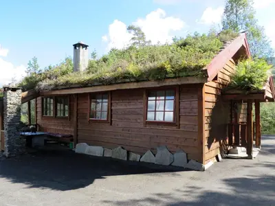 a log cabin with a grass roof on top of it at Chalet Anna by Interhome in Eikelandsosen